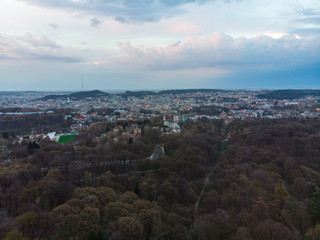 panoramic view of city park with city on background over sunset with dramatic sky
