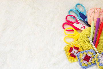 Concept of a woman's hobby. Knitting and work at home. Copy space. Multicolored balls of yarn, scissors, knitting needles, hooks. Materials for creativity and crafts.