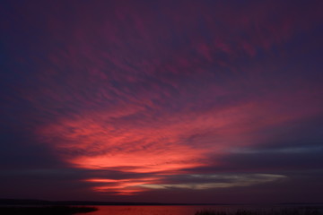 Naklejka na ściany i meble Bright colors of the twilight sky glow over the lake in the autumn evening