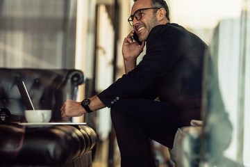 Businessman working from hotel lobby - obrazy, fototapety, plakaty