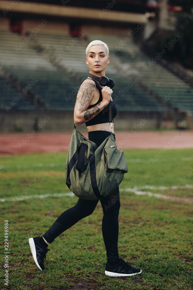 Wall mural Fitness woman walking inside a track and field ground