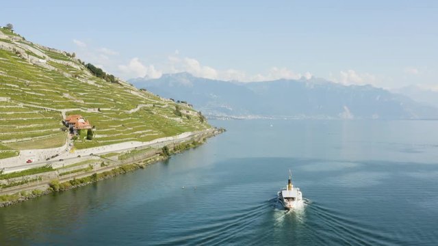 Aerial shot following CGN Belle-Epoque steam boat on Lake L&radic;&copy;man in front of Lavaux vineyard. Swiss train passing along the shore, the Alps in the background.
Vaud - Switzerland