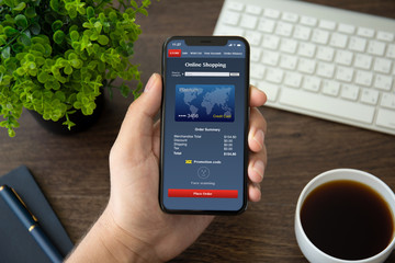 man hand holding phone with app online shopping on screen