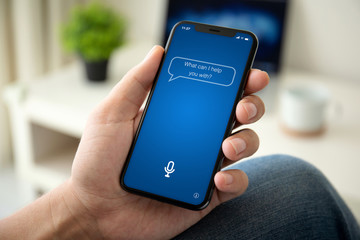 man hand holding phone with app personal assistant on screen