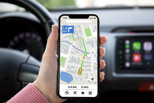 women hand holding phone with app navigation map on screen