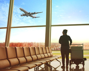single woman sitting in airport terminal and passenger plane flying outdoor for traveling theme