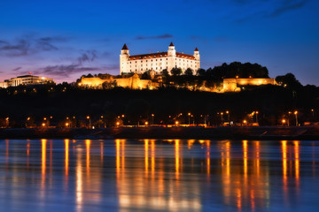 Bratislava castle at night, city lights reflection in Danube river
