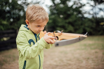 Little boy shoots from a toy crossbow
