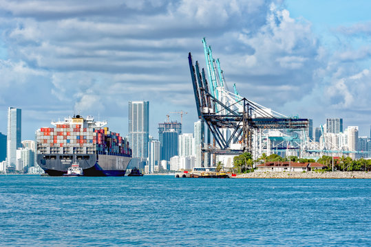 Tug guiding container ship into Port Miami