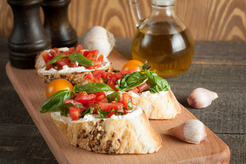Italian tomato and cheese bruschetta. Tapas, antipasti with chopped vegetables, herbs and oil on grilled ciabatta and baguette bread.