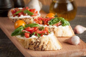 Italian tomato and cheese bruschetta. Tapas, antipasti with chopped vegetables, herbs and oil on grilled ciabatta and baguette bread.