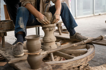 Potter hands makes on the pottery wheel clay pot	