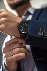 Elegant man with suit and watch on hand. - obrazy, fototapety, plakaty
