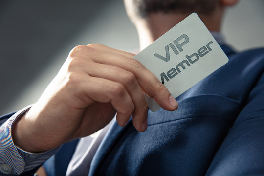 VIP member card holded by an elegant man in suit.