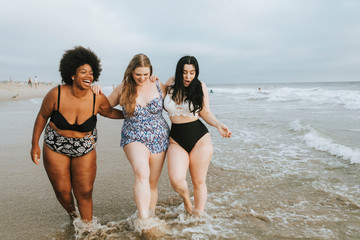Cheerful plus size women enjoying the beach