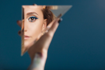 Woman looking at her self reflected in a mirror