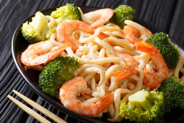 Healthy food: udon noodles with shrimps, broccoli and soy sauce close-up on a plate. horizontal