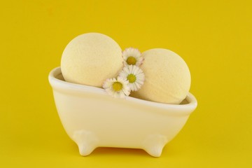 bath Bomb with chamomile extract. yellow round bath bombs with chamomile flowers in a decorative...