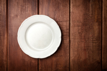 White plate, shot from above on a dark rustic wooden background with a place for text