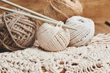 Fototapeta na wymiar Needlework, macrame, knitting. Yarn and thread of natural colors in a wicker basket. Women's hobby.
