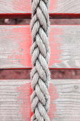 Fototapeta na wymiar Old rope and distressed red painted wood planks