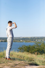 Portrait of a young handsome groom outdoors at sunset.