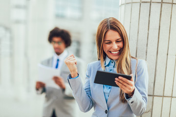 Businesswoman working on tablet computer outside office