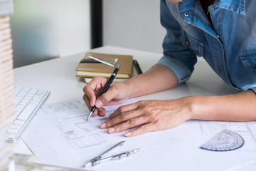 Architect working on blueprint, Engineer working with engineering tools for architectural project on workplace, Construction concept - building project, blueprints, ruler and dividers