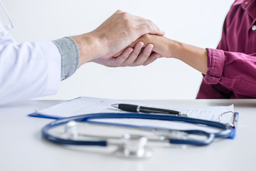 Doctor touching patient hand for encouragement and empathy on the hospital, cheering and support...