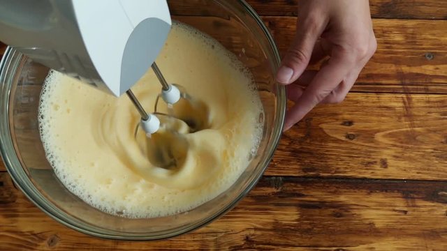 Woman mixing egss with flour for apple pie dought, top view slow motion video