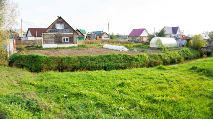 on the bank of a forest pond , kitchen gardens and greenhouses