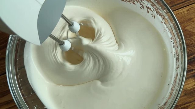 Woman mixing egss with flour, close-up slow motion