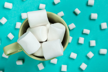 marshmallow laid out on blue paper background. pastel creative textured pattern.
