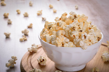 Salt popcorn on the wooden table, selective focus