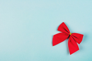 Single red tied bow on blue background with copy space for your text