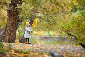 beautiful girl in knitted crown walks in autumn park