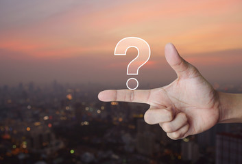 Question mark sign icon on finger over blur of cityscape on warm light sundown, Business customer service and support concept