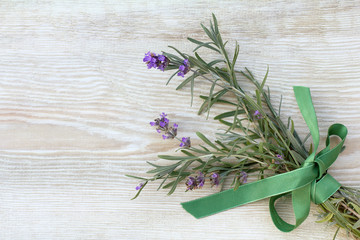Naklejka premium pachnący romantyczny kwiat / bukiet angielskiej lawendy ozdobiony zieloną kokardką na drewnianym stole
