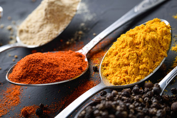 Various spices spoons on stone table.On dark concrete background.Herbs and spices on wooden table.  Top view with space for your text