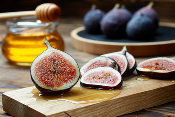 Cut figs on a wooden Board watered with honey. Rustic style.