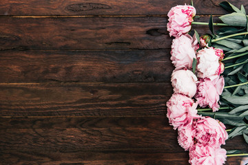 pink peony flowers on wooden background. Minimal flat lay composition with copy space.