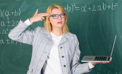 Educational reforms concept. Educator smart clever lady with modern laptop hold gun gesture at her...