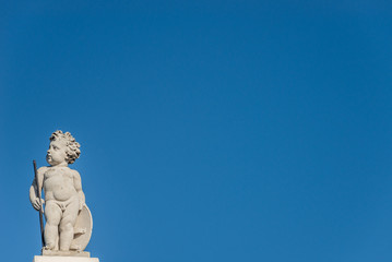 Beautiful angel as defender at the roof top in front of blue sky in Vienna, Austria, details, closeup