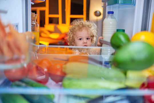 Toddler stealing food from fridge.  Picture taken from the iside of fridge.