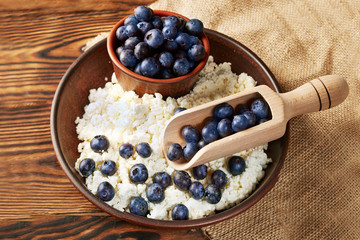Cottage cheese with blueberries on wooden background