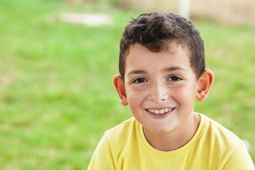 Portrait of happy cute child boy outdoors. Concept of happy family or successful adoption or parenting.