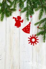 Christmas backdrop with decor and fir tree branch covered by snow over wooden texture.