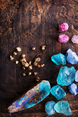 Treasure hunting. Mining for gems. Gold and gem stones on rough wooden surface.
