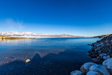   The frozen Sailimu lake with snow mountain background at Yili, Xinjiang of China
