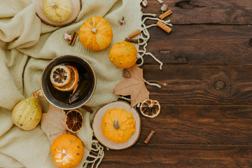 Flat lay, top view of vintage autumn composition. Pumpkins, dry leaves and hot tea